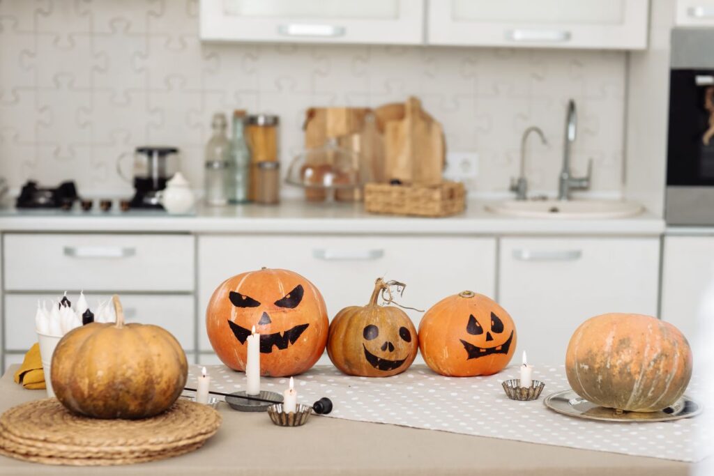 halloween pumpkin head jack lantern with burning candles. illuminated halloween pumpkins with candles in the kitchen.